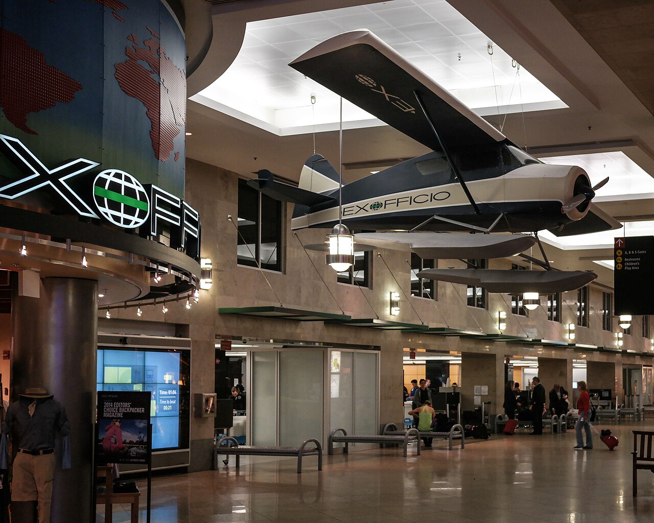 A Seattle-Tacoma airport concourse with shops and a suspended aircraft display