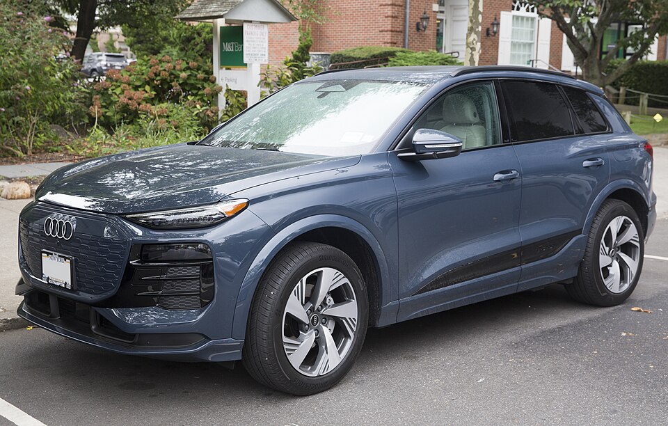A blue 2025 Audi Q6 e-tron photographed from the front left