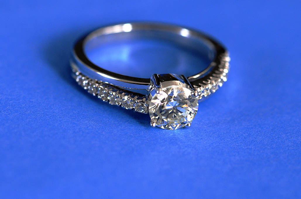 A diamond ring photographed against a blue background