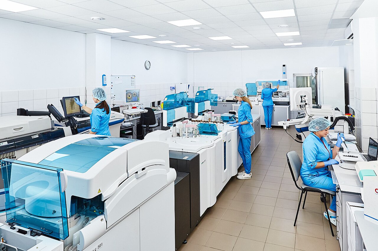 Staff in protective clothing working among laboratory instruments
