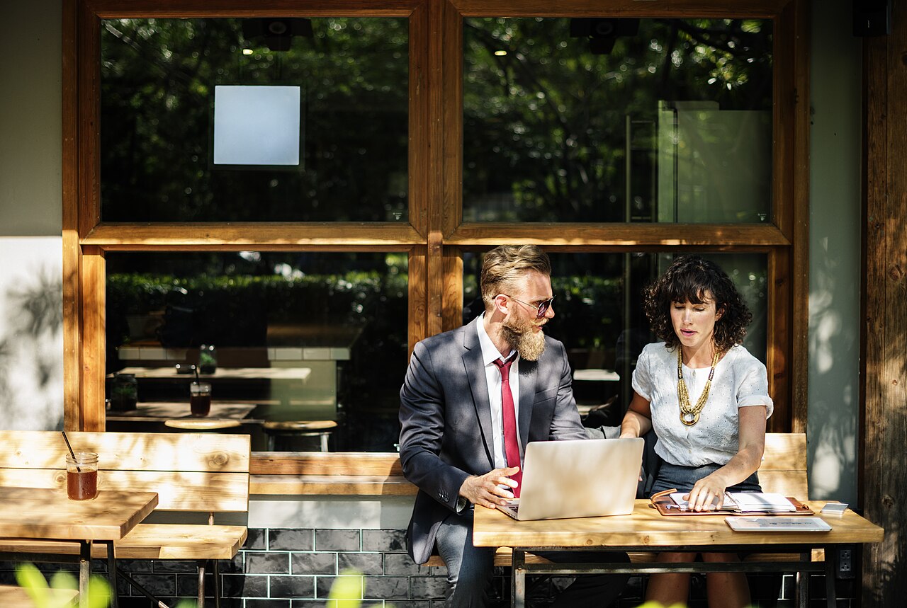 Two people working together at a table with a laptop